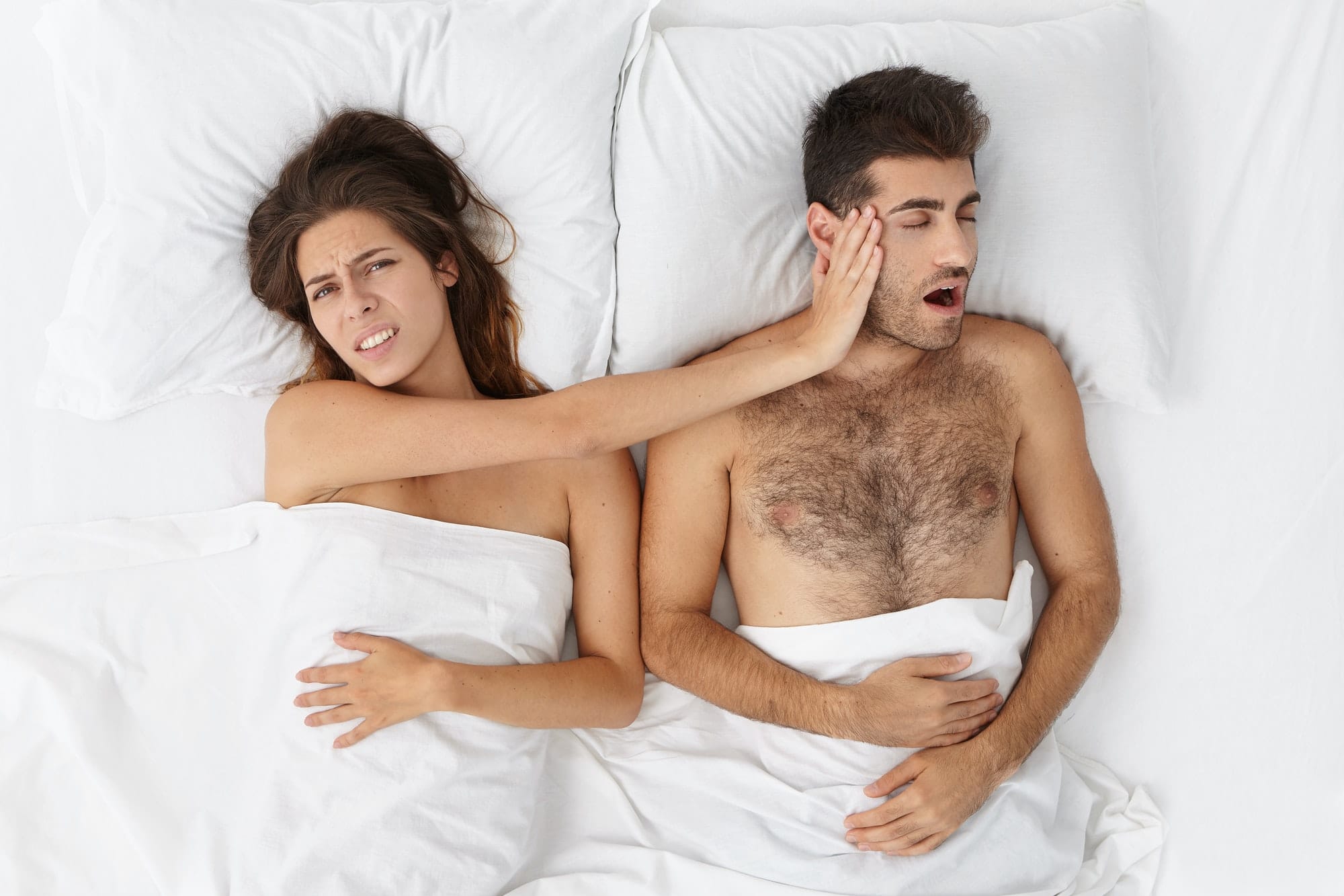 A woman irritated with her husband snoring next to her